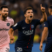 Alt Text: Joao Neves celebrates a goal for PSG with his finger raised, while Lionel Messi in an Inter Miami kit looks on and Achraf Hakimi stands nearby during the Club World Cup match.